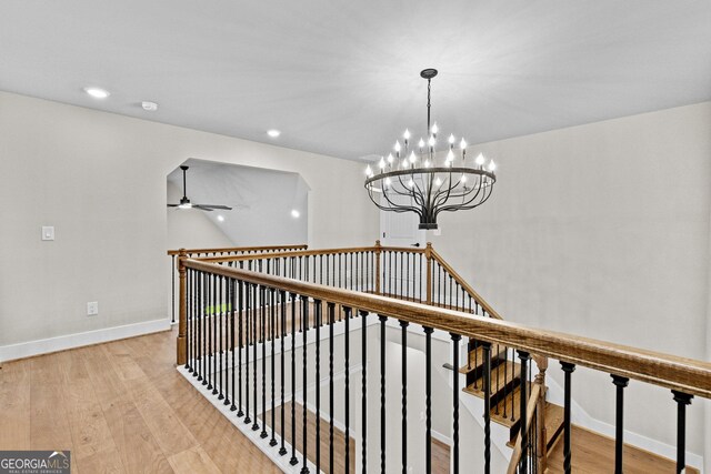 hall featuring light hardwood / wood-style floors and an inviting chandelier