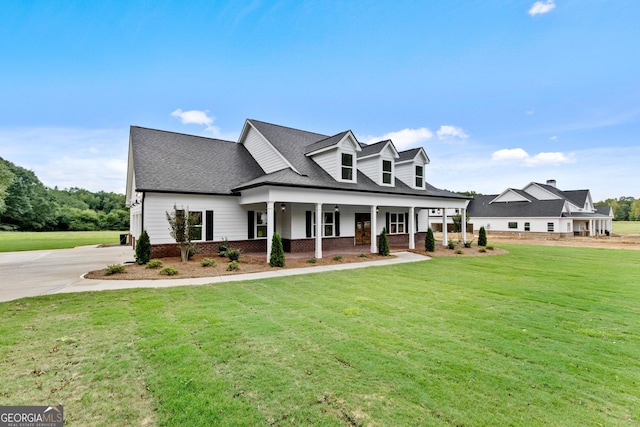 cape cod-style house featuring covered porch and a front lawn