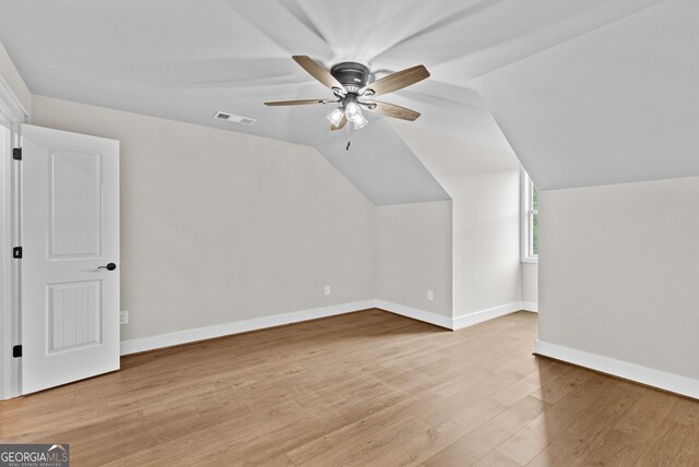 additional living space with ceiling fan, vaulted ceiling, and light wood-type flooring