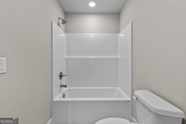 bathroom featuring tub / shower combination and toilet