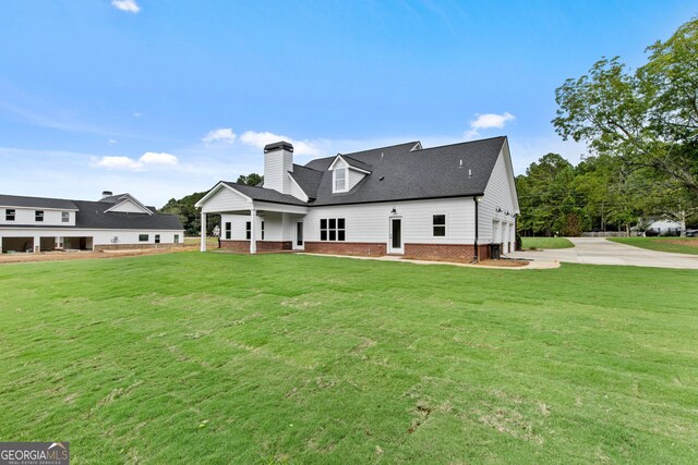 rear view of property featuring a yard and a garage