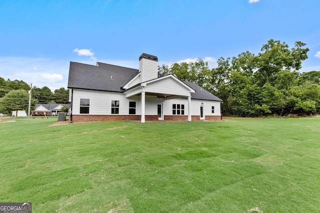 rear view of house featuring ceiling fan, central air condition unit, and a yard