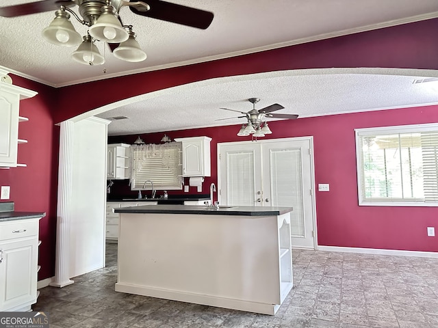 kitchen featuring ceiling fan, sink, french doors, white cabinets, and ornamental molding