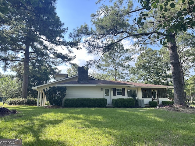 ranch-style house with central air condition unit and a front yard