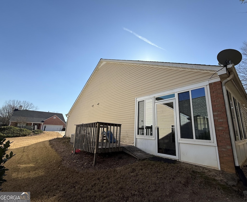 rear view of property featuring a wooden deck