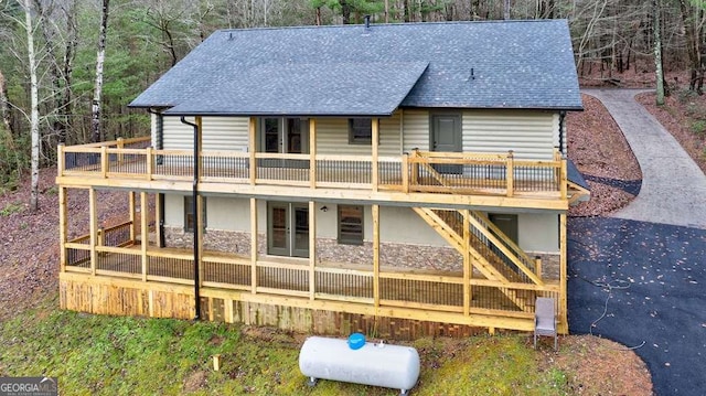 back of property with stairs, french doors, roof with shingles, and a wooden deck