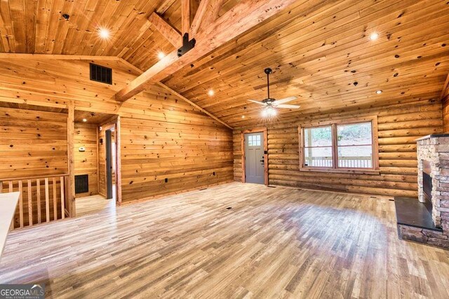 kitchen with stainless steel refrigerator with ice dispenser, decorative light fixtures, light hardwood / wood-style floors, a kitchen island, and wood walls