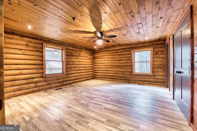 empty room featuring wood ceiling, rustic walls, wood finished floors, and a wealth of natural light