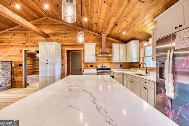 kitchen with white cabinets, hanging light fixtures, sink, wall chimney exhaust hood, and appliances with stainless steel finishes