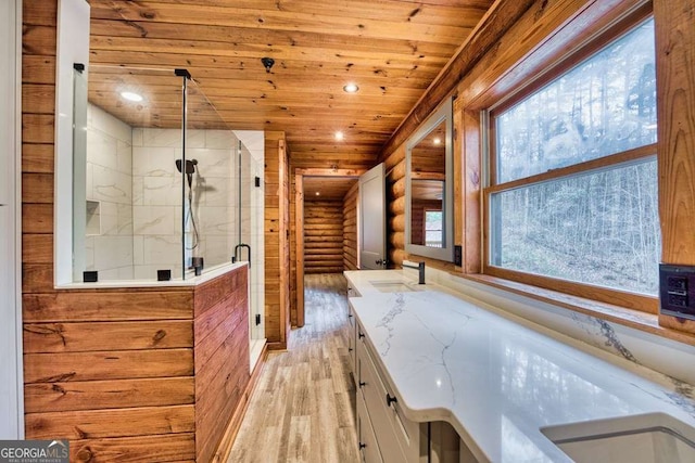 bathroom featuring log walls, a marble finish shower, wood ceiling, vanity, and wood finished floors