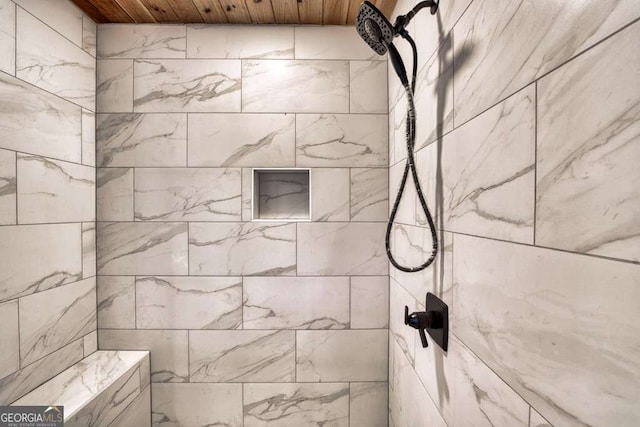 bathroom with a tile shower and wood ceiling