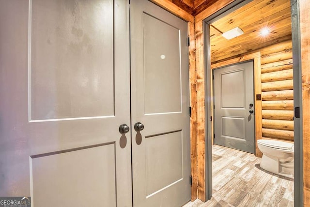 corridor with light wood-style floors and log walls