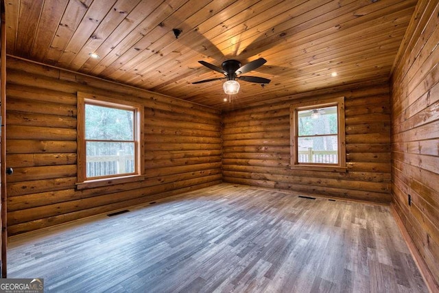 spare room featuring a wealth of natural light, wooden ceiling, visible vents, and wood finished floors