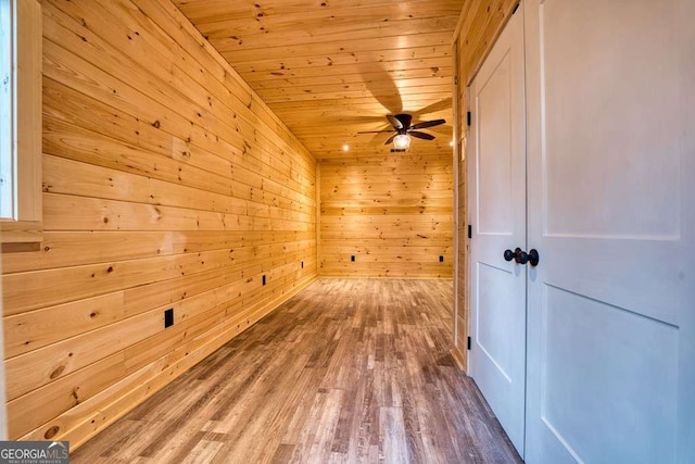 bonus room featuring hardwood / wood-style floors, wooden walls, ceiling fan, and wooden ceiling