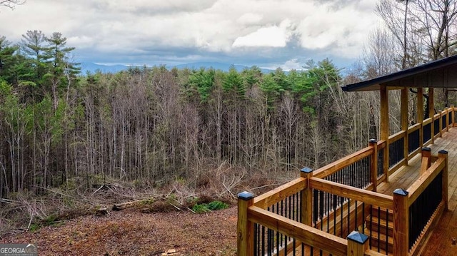 view of yard featuring a deck and a view of trees