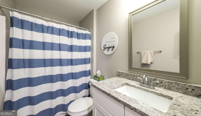 bathroom with vanity, toilet, and curtained shower