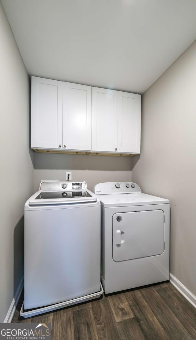 washroom featuring cabinets, dark hardwood / wood-style flooring, and washing machine and dryer