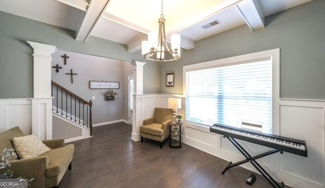 sitting room featuring decorative columns, beam ceiling, dark hardwood / wood-style floors, and an inviting chandelier