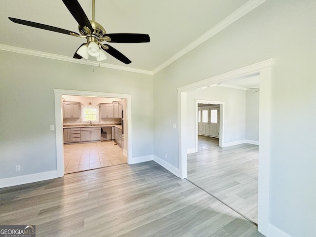 unfurnished living room with ceiling fan, sink, ornamental molding, and light wood-type flooring