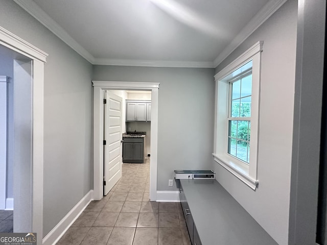 hallway featuring light tile patterned floors and ornamental molding