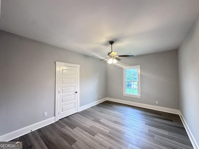 empty room featuring dark hardwood / wood-style flooring and ceiling fan