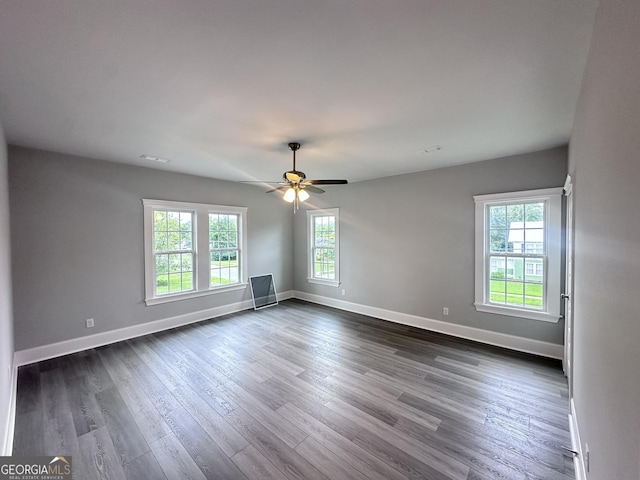 spare room with dark hardwood / wood-style flooring, plenty of natural light, and ceiling fan