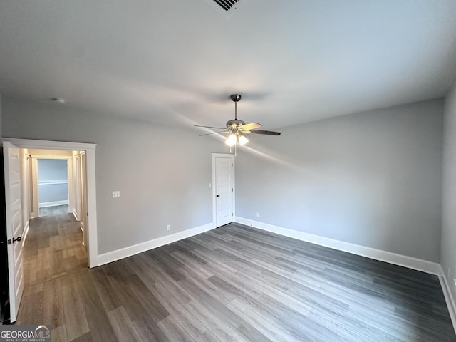 spare room with dark hardwood / wood-style flooring and ceiling fan