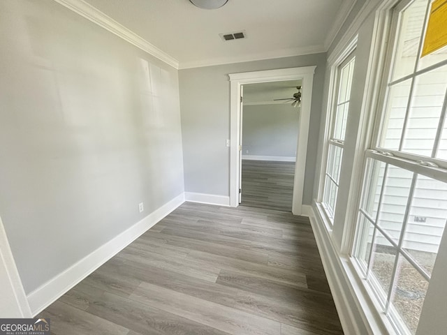 hallway featuring hardwood / wood-style flooring, a healthy amount of sunlight, and ornamental molding