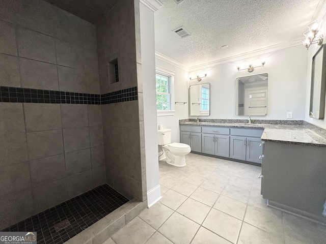 bathroom featuring tile patterned flooring, crown molding, a textured ceiling, toilet, and vanity