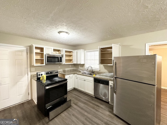 kitchen with dark hardwood / wood-style flooring, stainless steel appliances, white cabinetry, and sink