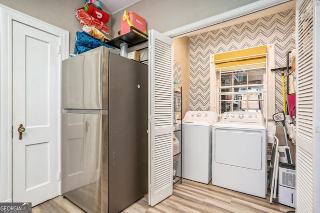 washroom with washer and dryer and light wood-type flooring