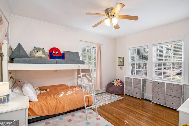 bedroom with hardwood / wood-style floors, ceiling fan, and ornamental molding