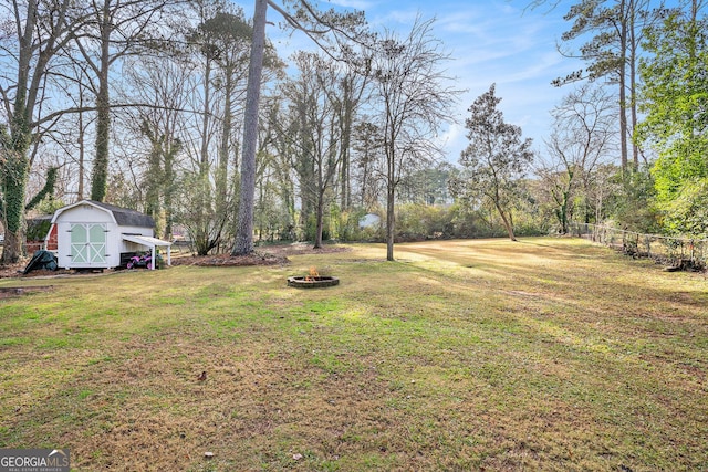 view of yard featuring an outdoor fire pit and a storage shed