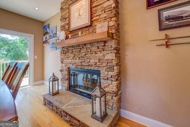 living room with light wood-type flooring and a stone fireplace