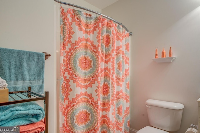 bathroom with toilet and curtained shower