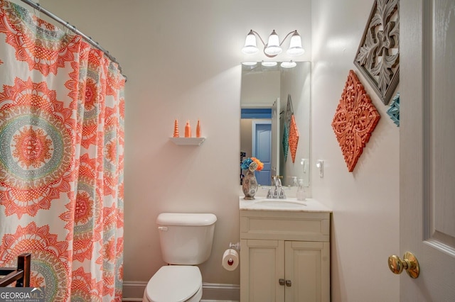 bathroom featuring curtained shower, vanity, and toilet