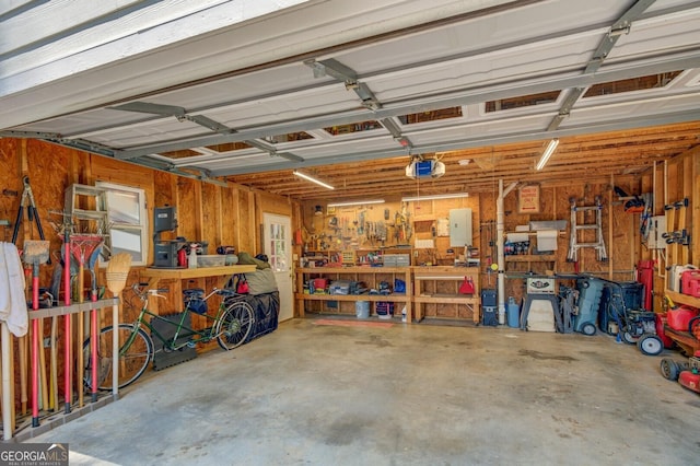 garage with a workshop area and a garage door opener