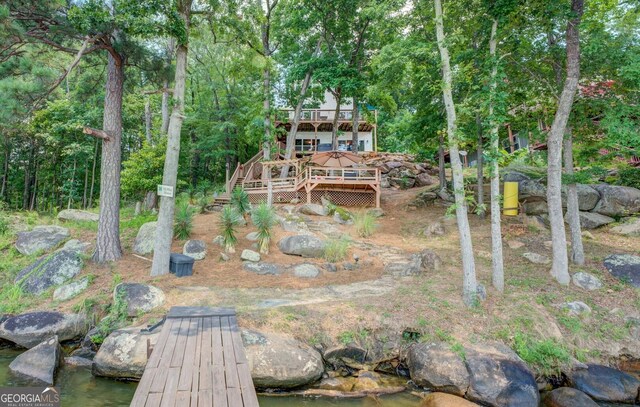 rear view of property with a deck with water view