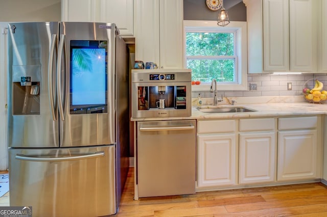 kitchen with white cabinetry, sink, light wood-type flooring, and appliances with stainless steel finishes