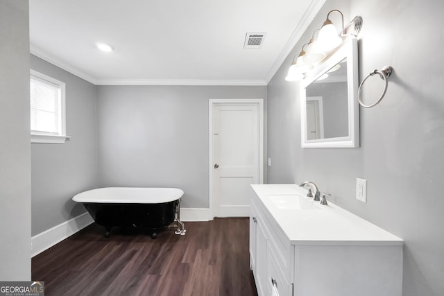 bathroom with hardwood / wood-style flooring, vanity, ornamental molding, and a tub