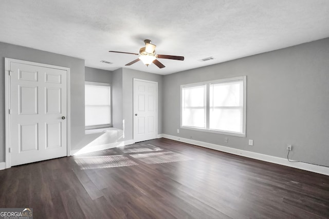 interior space with ceiling fan, dark wood-type flooring, and a textured ceiling