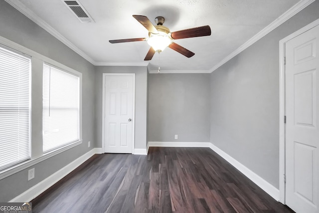 unfurnished room featuring ceiling fan, dark wood-type flooring, and ornamental molding