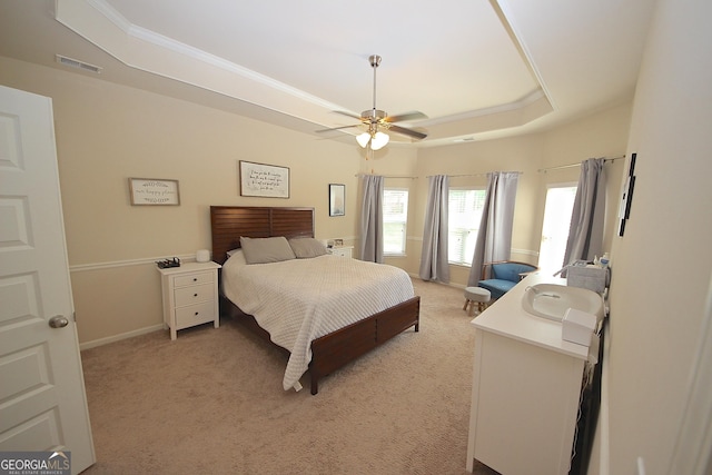 carpeted bedroom featuring ceiling fan and a raised ceiling