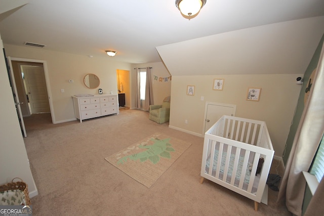 carpeted bedroom featuring lofted ceiling and a crib