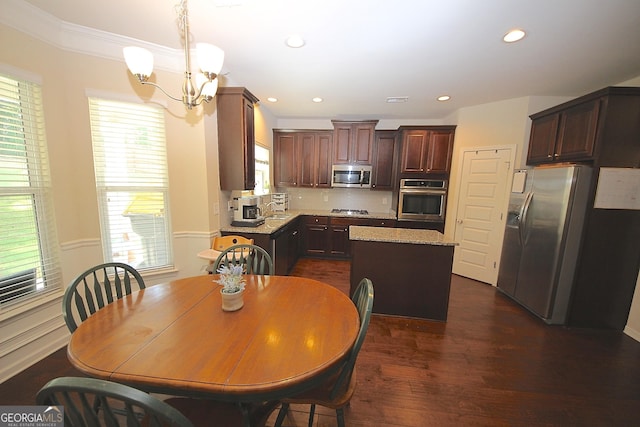 kitchen featuring dark hardwood / wood-style flooring, stainless steel appliances, a chandelier, a center island, and hanging light fixtures