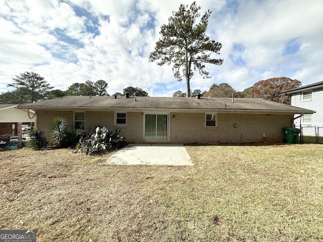 rear view of property with a patio and a lawn