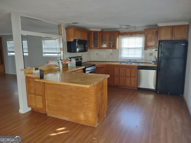 kitchen with dark hardwood / wood-style flooring, sink, backsplash, and black appliances