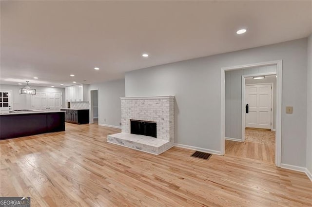 unfurnished living room with a fireplace and light hardwood / wood-style flooring