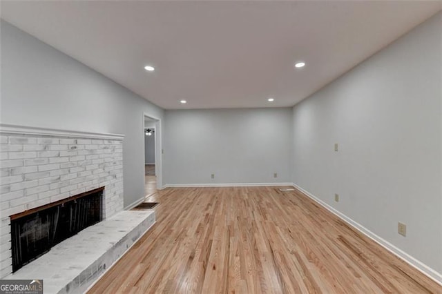 unfurnished living room with a fireplace and light hardwood / wood-style floors