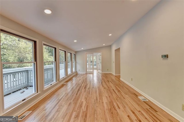 unfurnished living room with light hardwood / wood-style flooring and vaulted ceiling